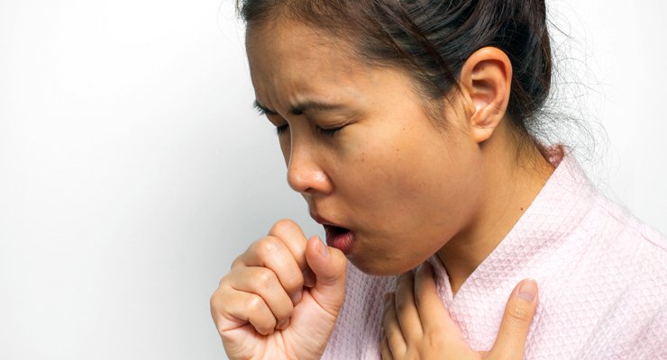 Woman covering her mouth while coughing