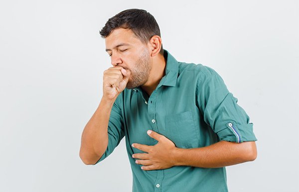 Young man suffering from cough looking ill