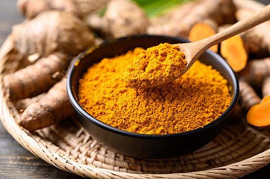 Turmeric in a bowl and spoon full of turmeric