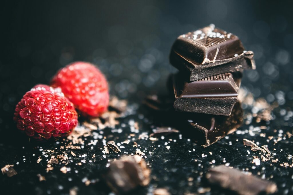  Stacked Chocolates Bars Beside Raspberries